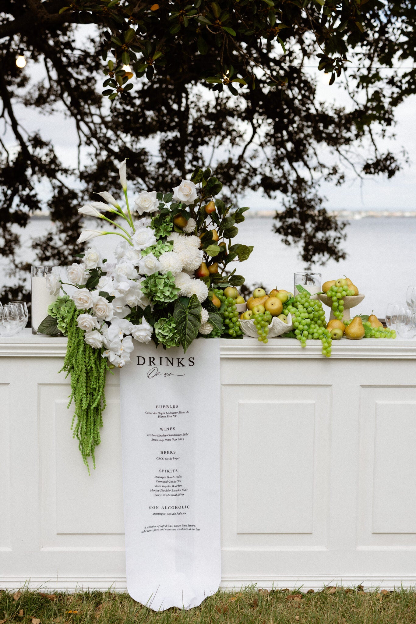 Decorative setup with flowers, fruits, and a menu board outdoors. Matilda Bay Reserve Perth Wedding