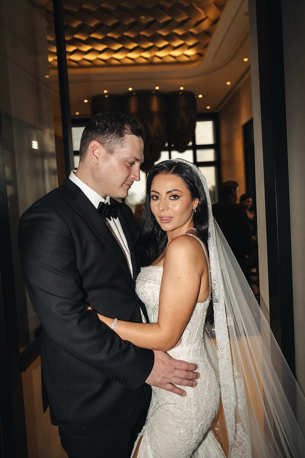 Man and woman in formal attire standing close together indoors. Crown Perth 
