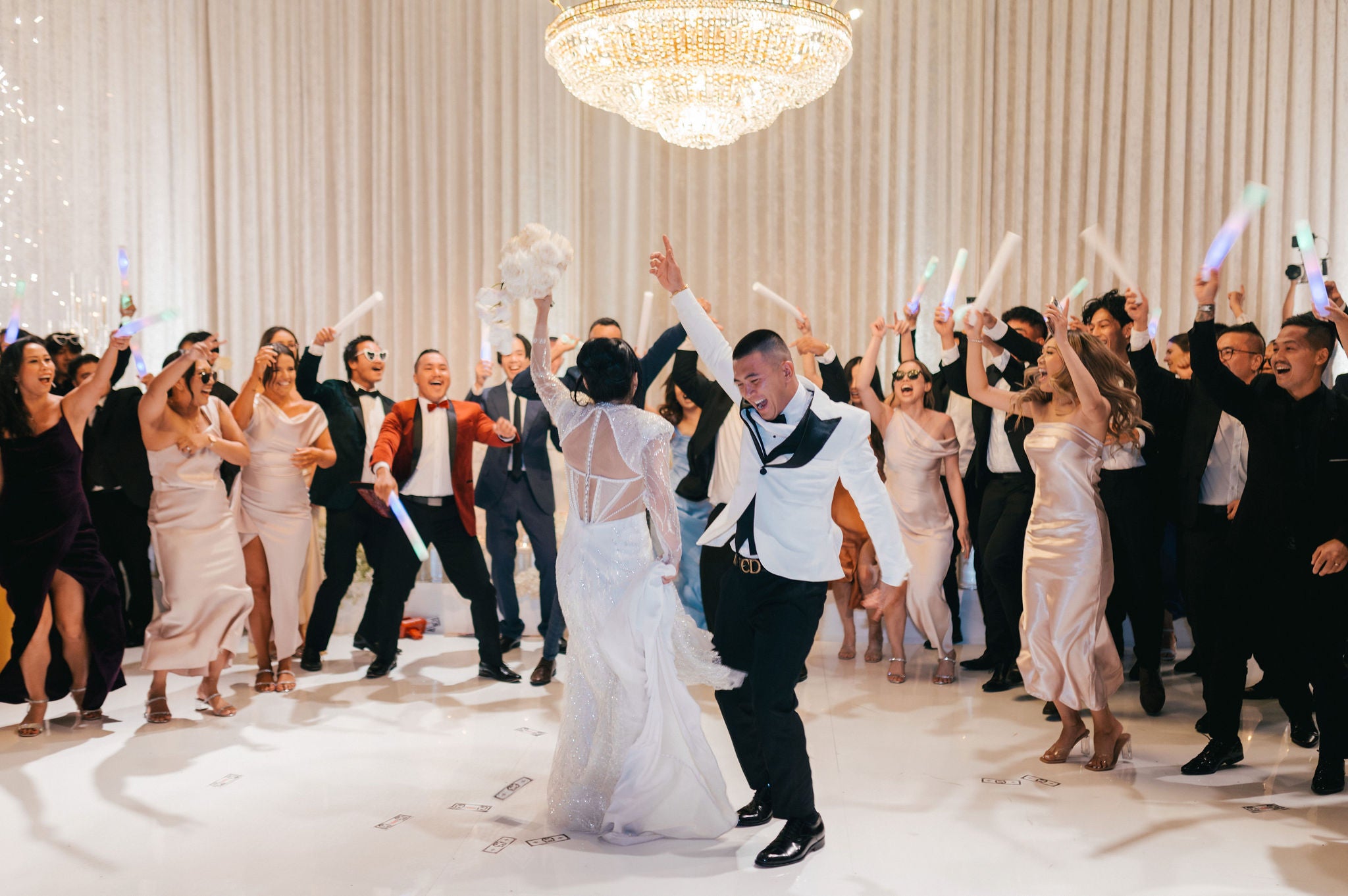 Bridal Party Dancing at wedding with large chandelier and luxury design
