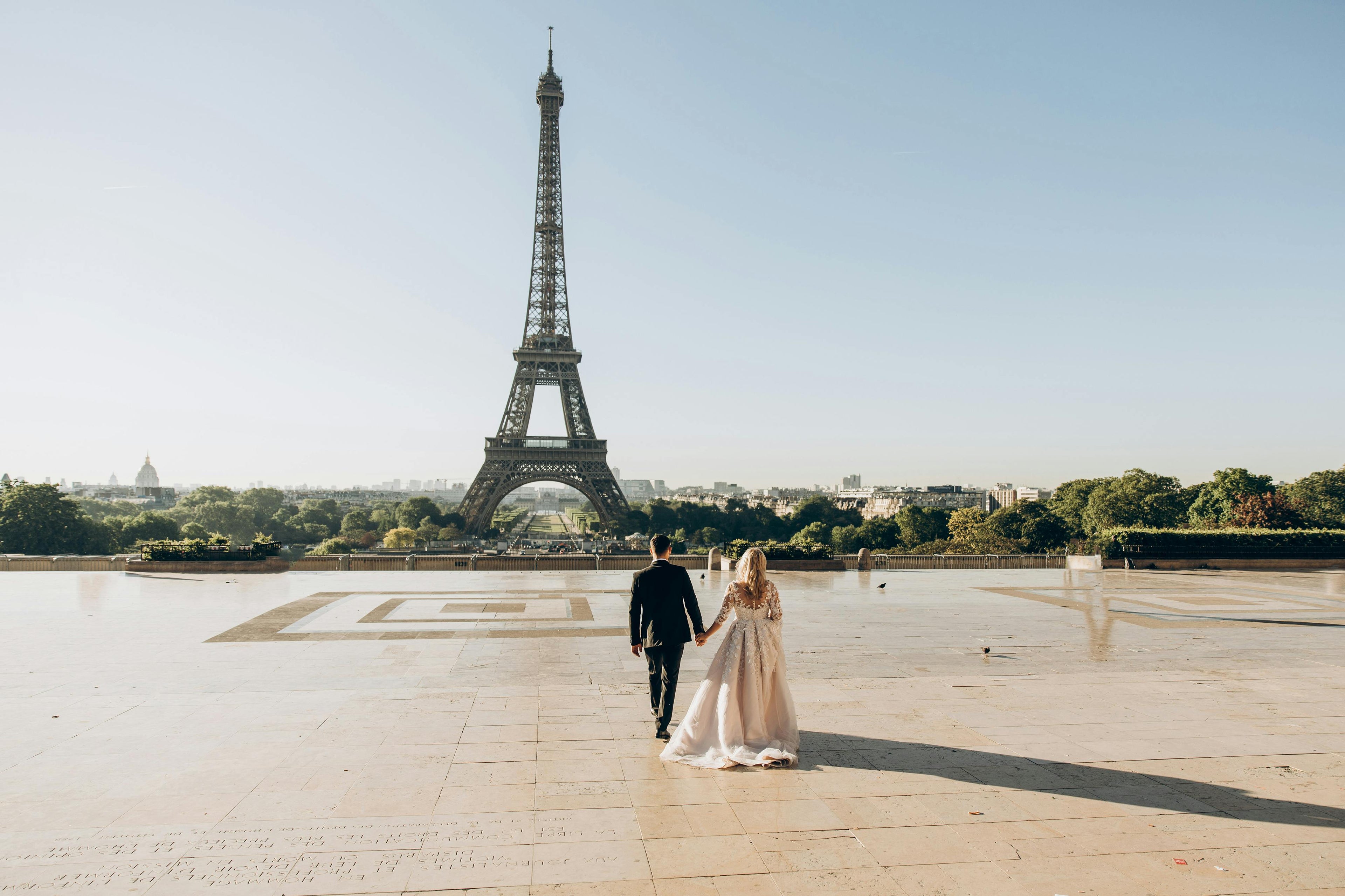 Image of couple walking towards the Eiffel tower in Paris for their wedding day 