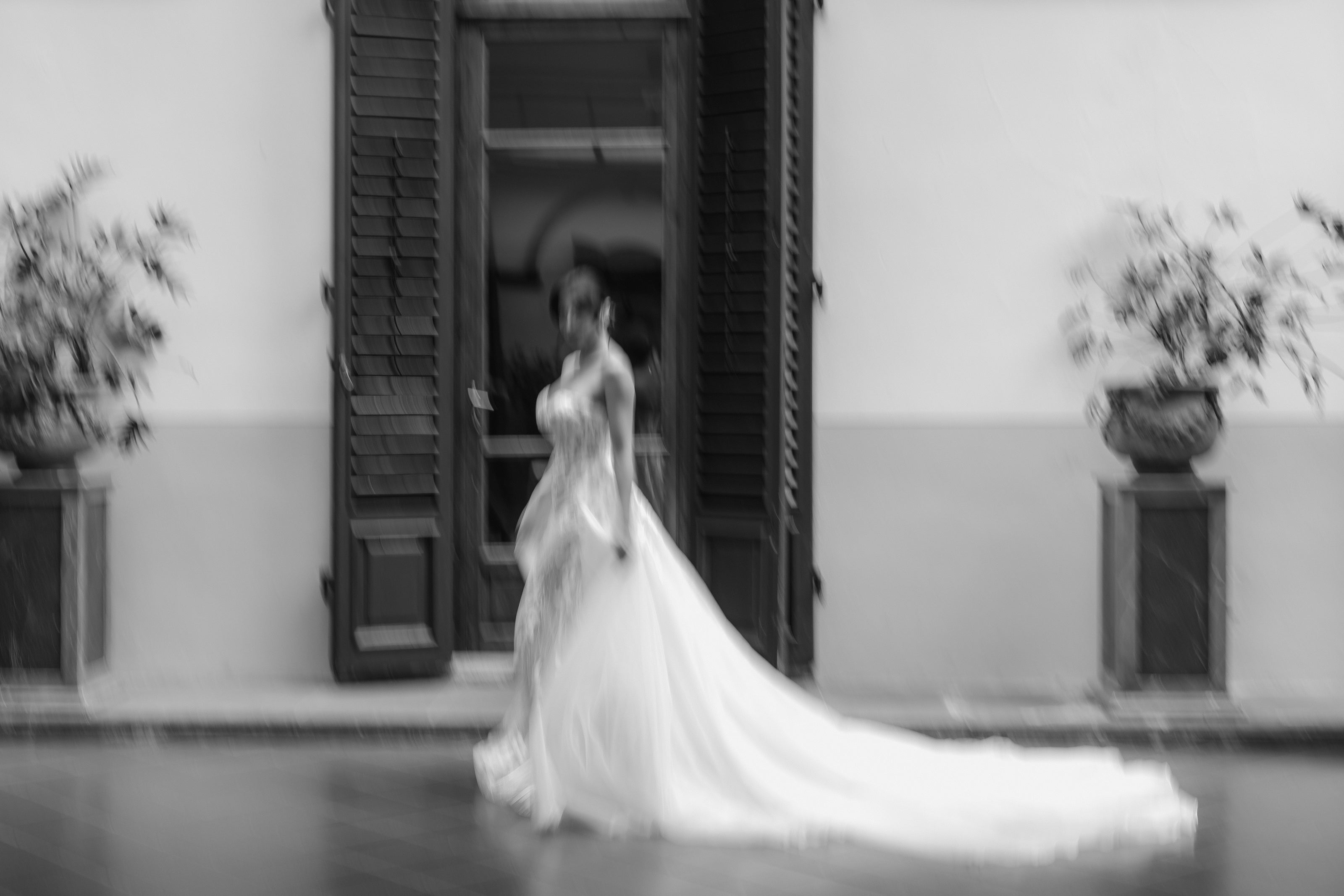 Bride walking down outdoor aisle with long white veil at Villa Castelletti in Tuscany Italy